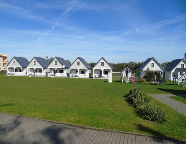 A row of white houses with grey roofs, each with a porch and a small deck. - Comfortable Holiday Homes, Close to the sea (Ustronie Morskie)