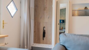 A modern living room with a wooden wardrobe, a small window, and a sofa.