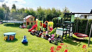 A playground with various play structures, a small house, and a trampoline. - Comfortable Holiday Homes, Close to the Beach (Mielno)