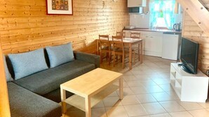 A cozy cabin interior with a wooden interior, a sofa, a dining table, and a kitchen area. - Comfortable Holiday Homes, Close to the Beach (Mielno)