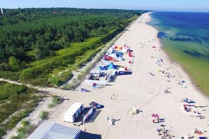Una playa con tiendas de campaña y gente que disfruta.