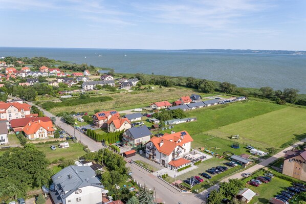 A coastal residential area with houses, a marina, and a large body of water.
