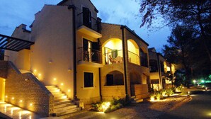 A multi-story building with a balcony, steps leading to the entrance, and outdoor lighting. - Zaton Apartment Near Sea Beach (Nin)