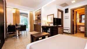 A hotel room with a bed, a desk, a TV, a mirror, and a bathroom visible through an open door. - Zaton Apartment Near Sea Beach (Nin)