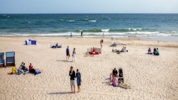A beach with people relaxing and walking along the shore. - Apartment in Mrzezyno by Blue Flag Beach (Trzebiatow)