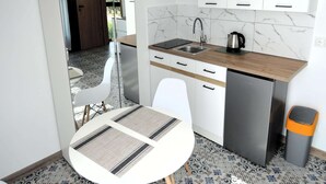 A compact kitchen with white cabinets, a stainless steel sink, and a coffee maker. - Apartment in Mrzezyno by Blue Flag Beach (Trzebiatow)