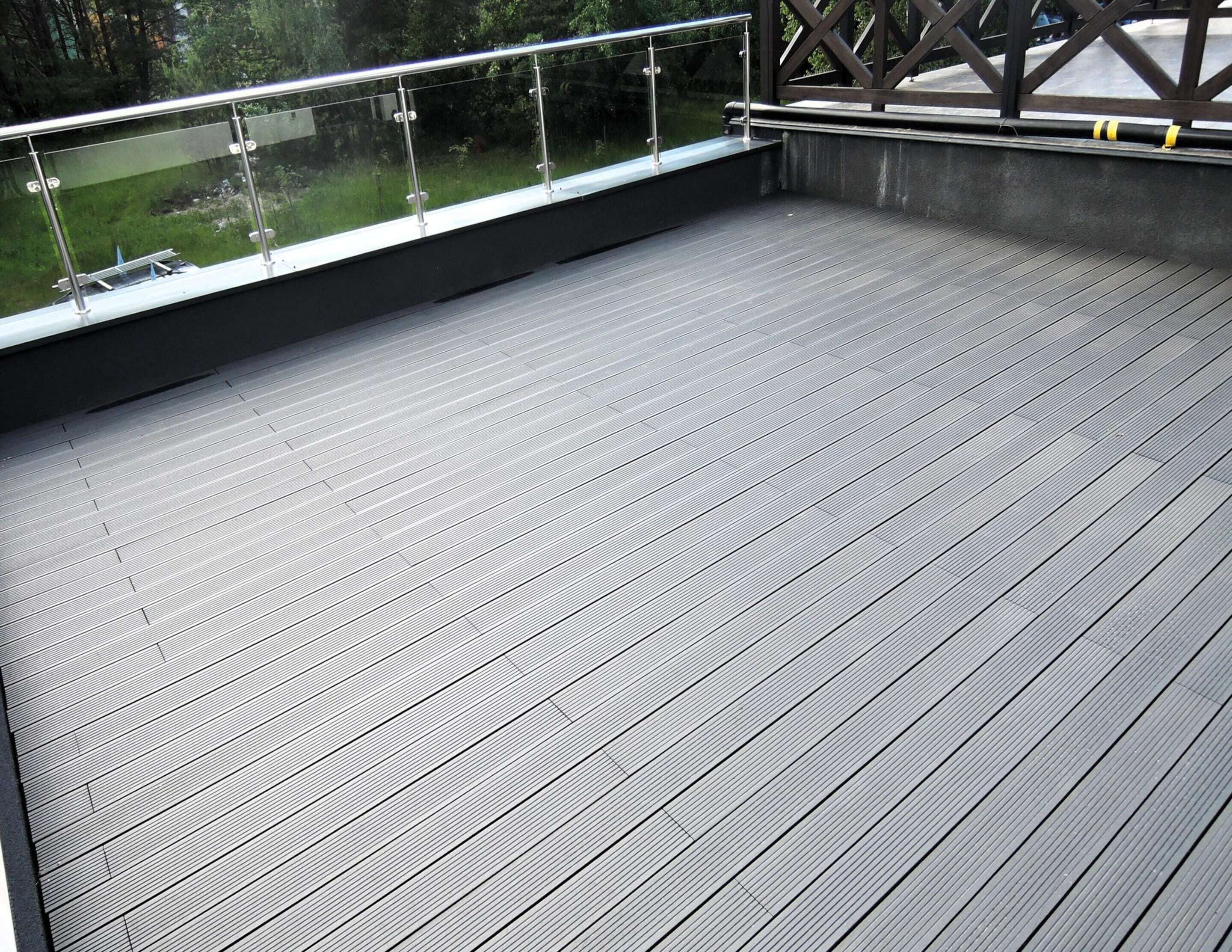 Una amplia terraza al aire libre con baranda de metal y vista a un paisaje verde.