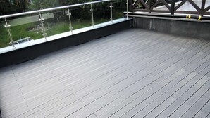 A spacious outdoor deck with a metal railing and a view of a green landscape. - Apartment in Mrzezyno by Blue Flag Beach (Trzebiatow)