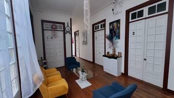 Una sala de estar con una mesa de centro de vidrio, dos sofás y una araña.