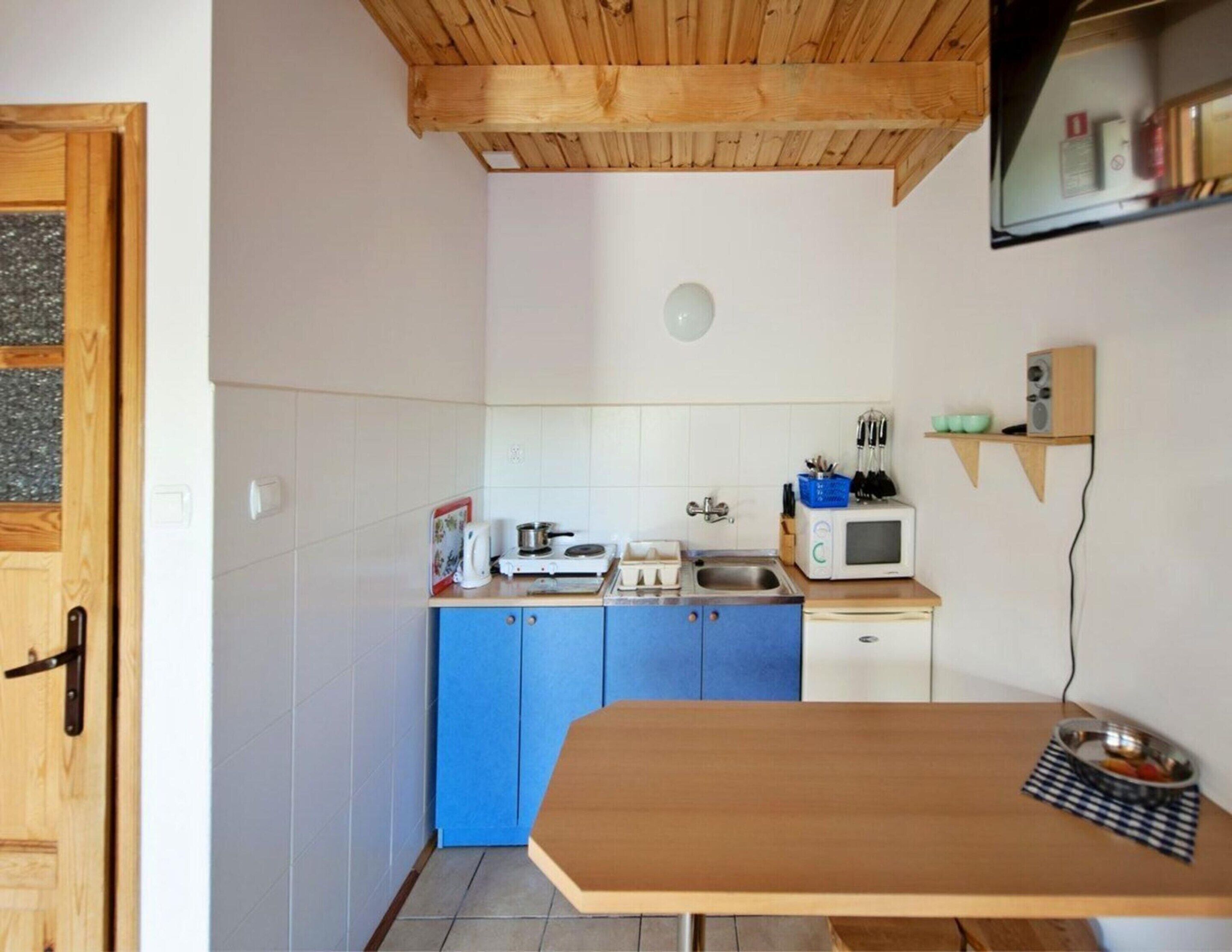 Une cuisine compacte avec des meubles en bois, un four à micro-ondes et un petit plan de travail.