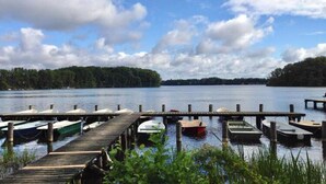 A lakeside dock with several boats moored at wooden piers. - Holiday Home Seeblick With Sauna on Lake Dummer, Dummer (Dümmer)