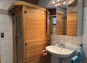 A bathroom with a wooden vanity, a white sink, a mirror, and a towel rack. - Ferienwohnung, Clausthal-zellerfeld (Clausthal-Zellerfeld)