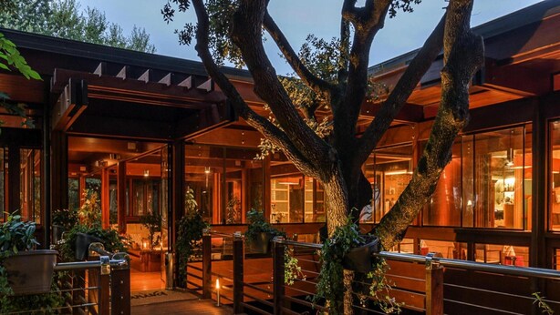 A wooden deck with a railing, surrounded by potted plants and trees. - Bungalow Riva Degli Etruschi in San Vincenzo-formerly TUI Ferienhaus (San Vincenzo)