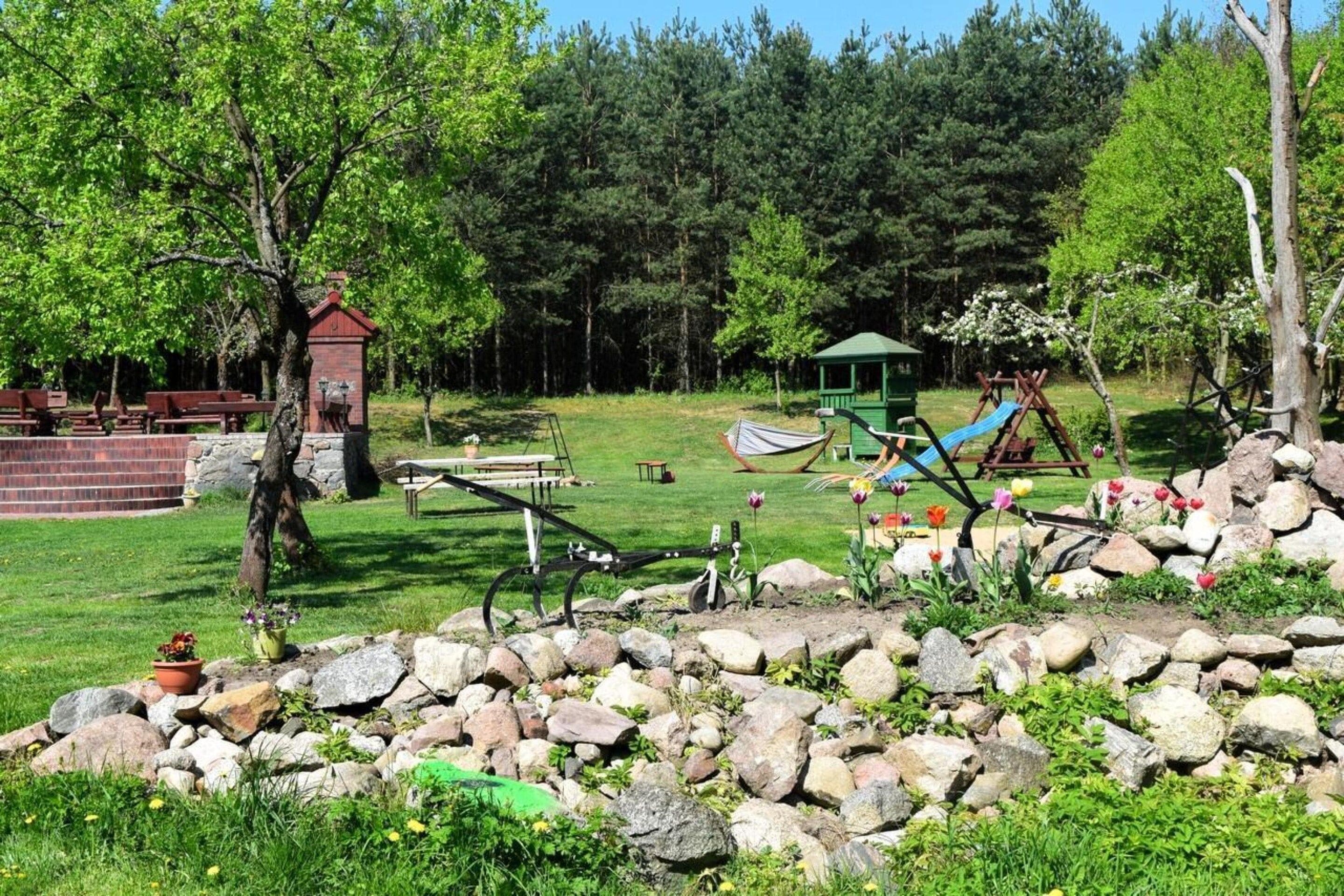A park with picnic tables, a swing set, and a small gazebo.