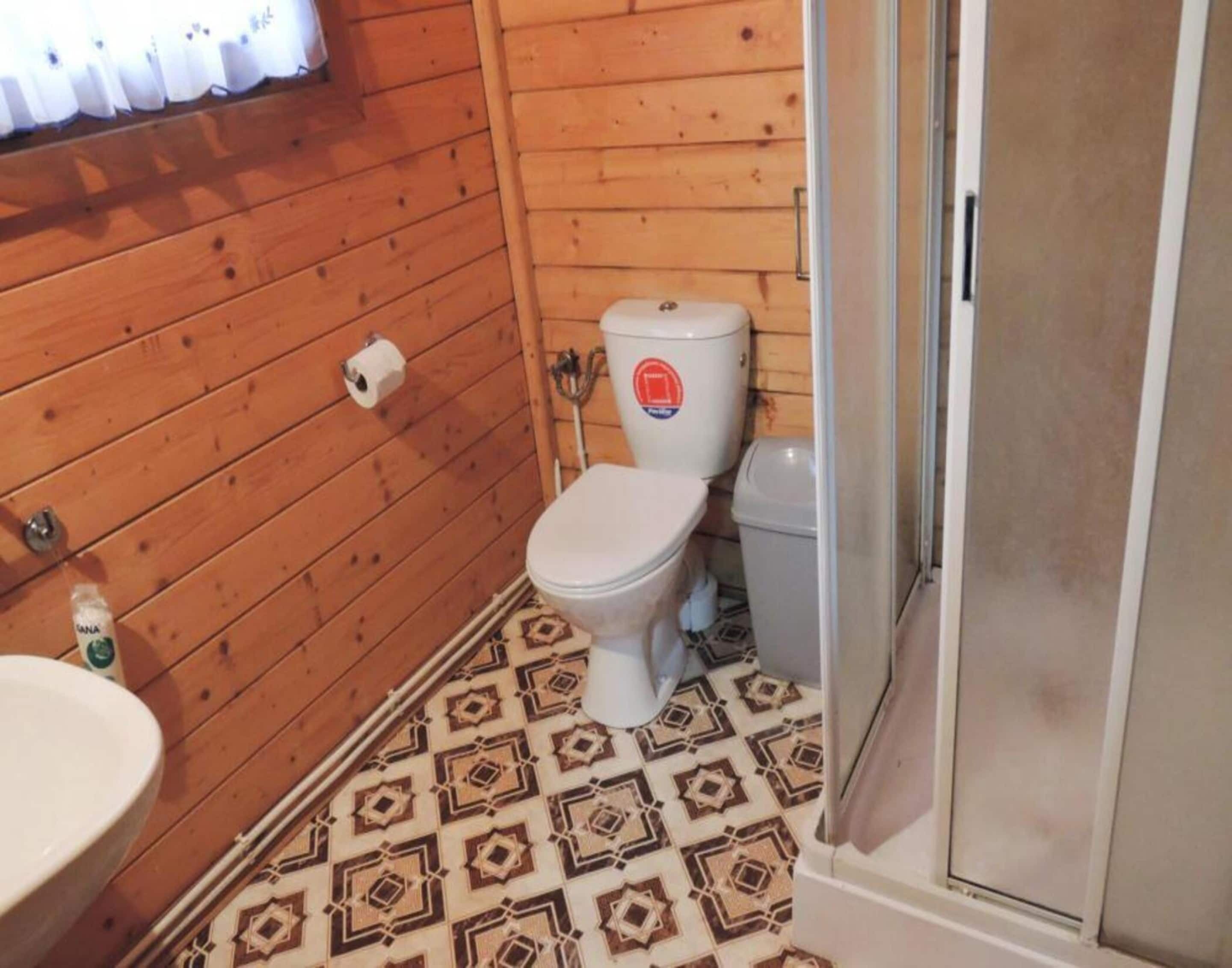Ein kleines Badezimmer mit Toilette, Waschbecken und einem Musterfußboden.