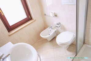 A modern bathroom with a bidet, toilet, and sink. - residence del mare (Ardea)