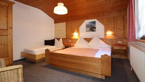 A wooden cabin bedroom with two beds, a wooden ceiling, and a wall-mounted picture. - Apartments Home Mario, See im Paznauntal (See)