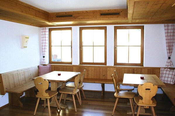 Guests can sit at the two tables with benches in this traditional room.