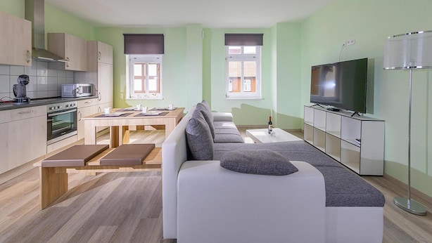 Un appartamento moderno con cucina, sala da pranzo e soggiorno.