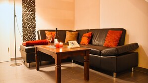 Un salon moderne avec un canapé en cuir, une table basse en bois et un lampadaire.