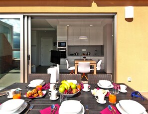 A breakfast table set with plates, cups, and a bowl of fruit. - Apartment in Las Palmas de Gran Canaria (Las Palmas de Gran Canaria)