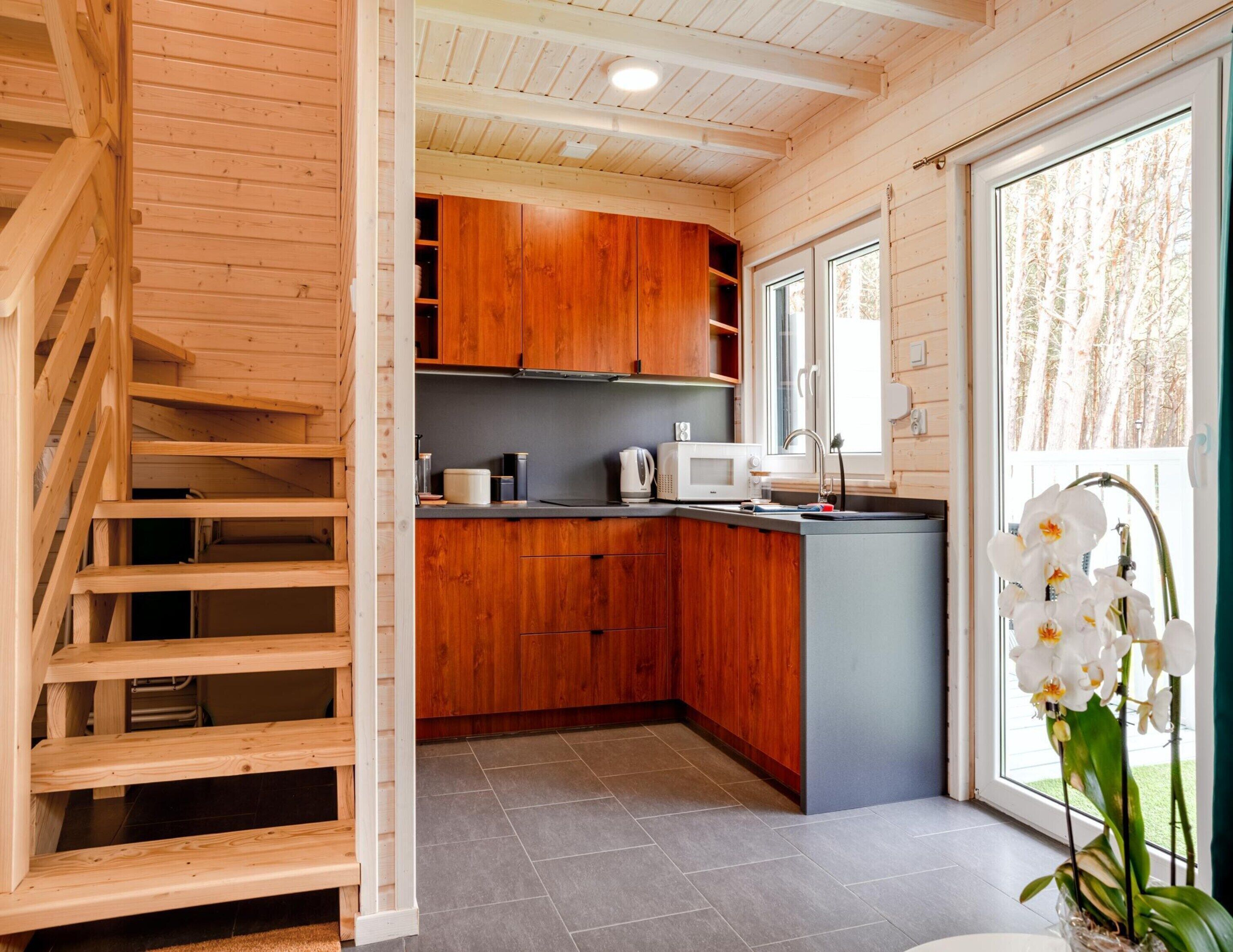 Une cuisine moderne avec des meubles en bois, un four à micro-ondes et un évier.