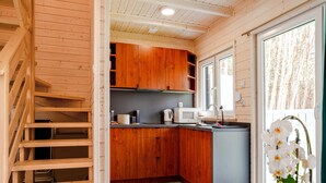 Eine moderne Küche mit Holzausstattung, einer Mikrowelle und einem Spülbecken.