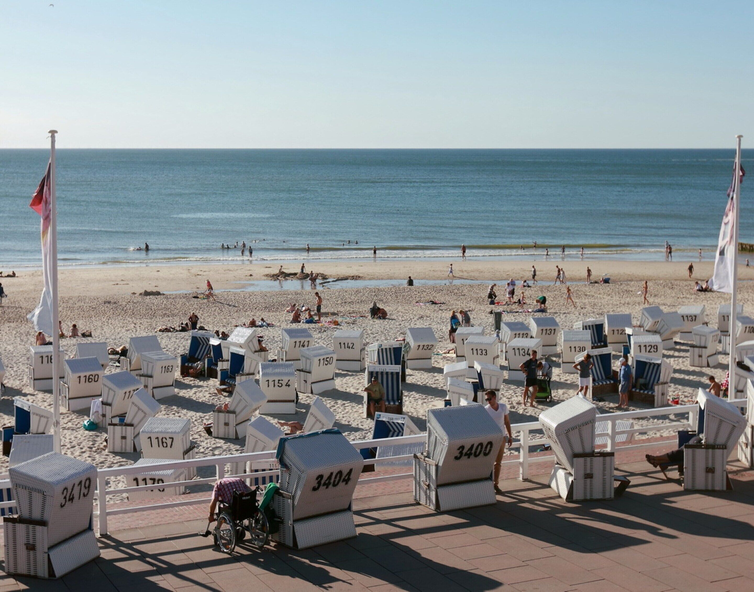 A beachside hotel with numbered beach chairs and a wheelchair-accessible area.