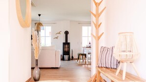 Un salon avec un canapé, une table basse en bois, une lampe et une cheminée.