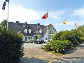 Ein Gebäude im traditionellen Baustil, mit einem steilen Satteldach und einer symmetrischen Fassade mit zahlreichen Fenstern.