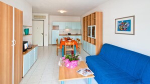 A compact living space with a kitchenette, a dining area, and a sofa. - Residence Cristoforo Colombe Caorle (Caorle)