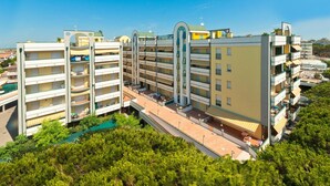 A multi-story hotel with balconies, a central atrium, and a pool area. - Residence Cristoforo Colombe Caorle (Caorle)