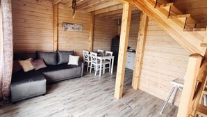 A wooden interior with a sofa, dining table, and staircase. - Holiday Home in Niechorze With Garden (Rewal)