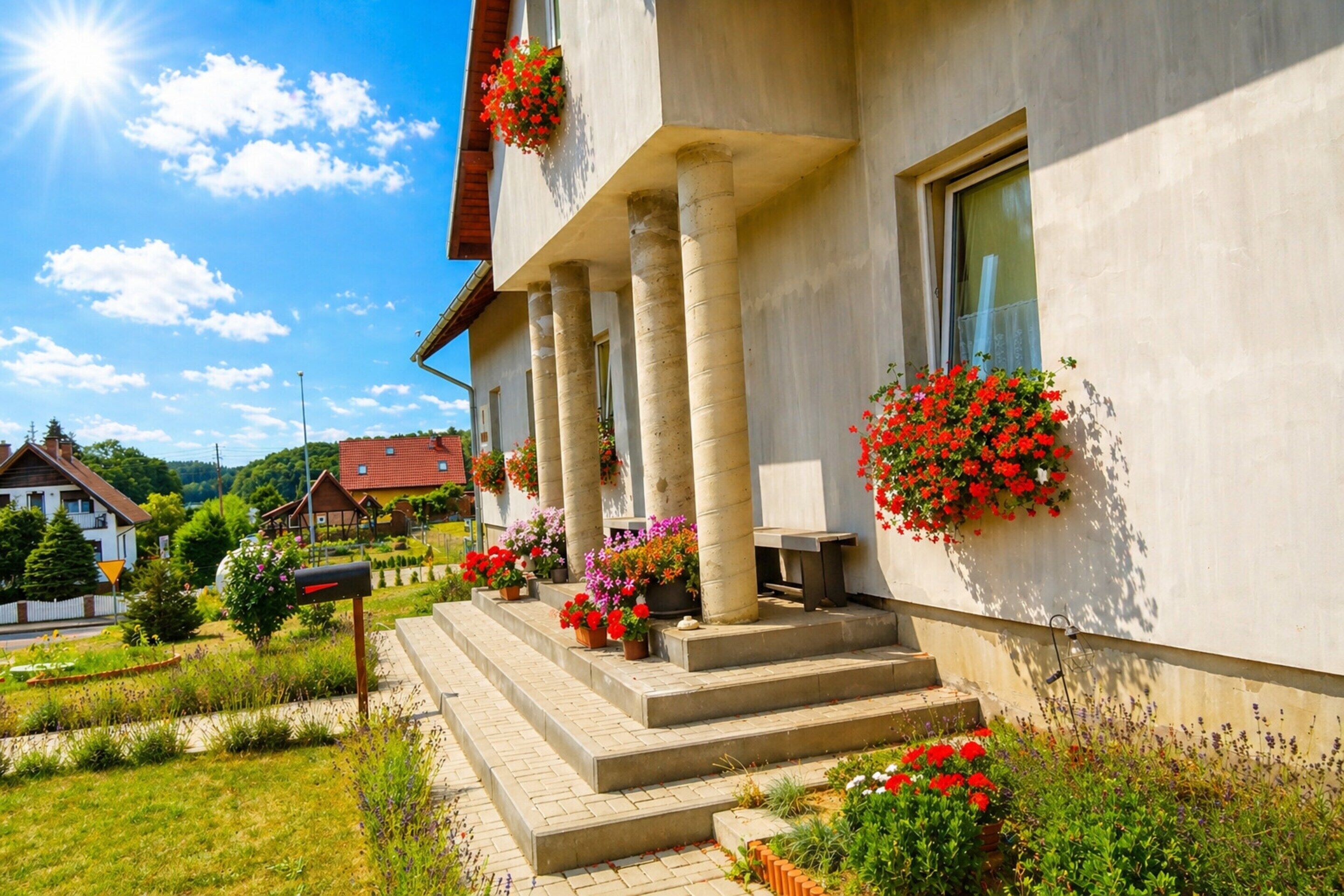 Ein Gebäude mit Veranda, Treppen und Blumenkästen.