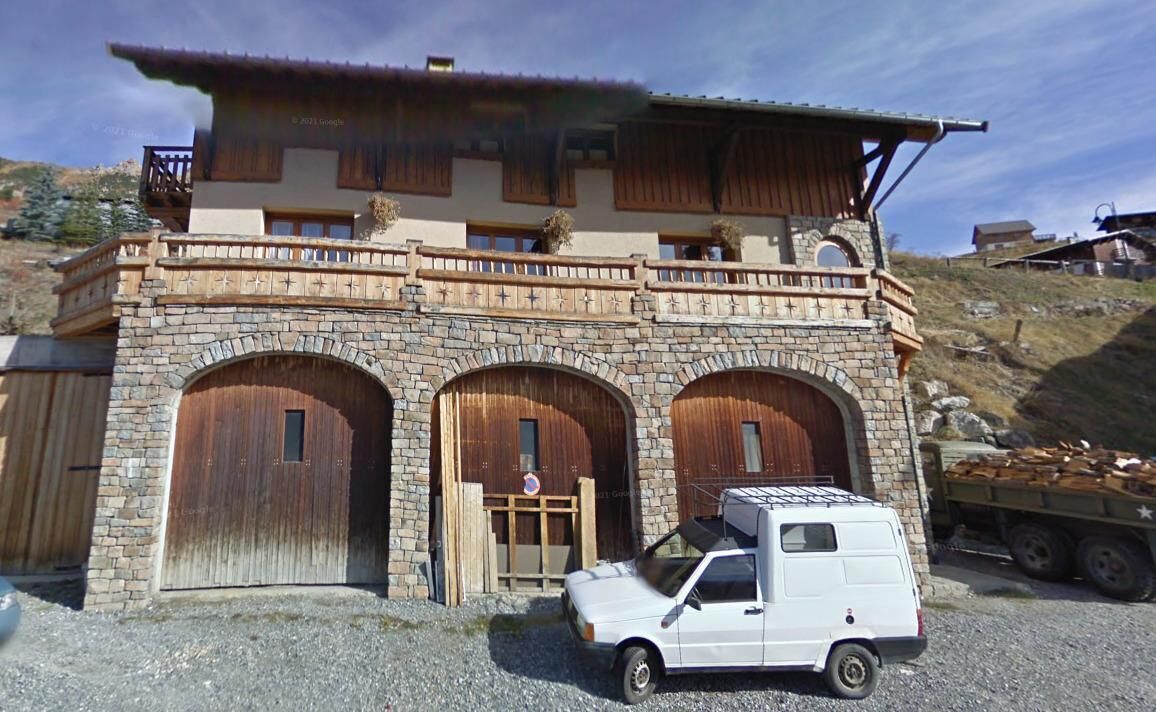 Un bâtiment à deux  étages doté d’une façade en pierre, de portes en bois et d’un balcon.