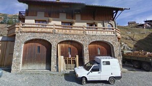 Un bâtiment à deux étages doté d’une façade en pierre, de portes en bois et d’un balcon.