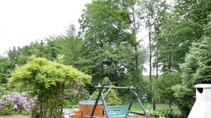 A park with a swing set, a hot tub, and a stone pathway. - Holiday Home in Zakowo Near Lake (Suleczyno)