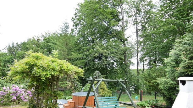 Un parc équipé d’une balançoire, d’un jacuzzi et d’un sentier en pierre.
