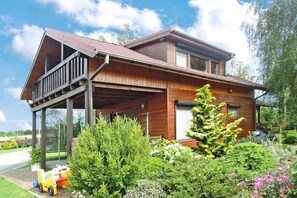 Enjoy the serene surroundings from the upper balcony of this cozy cabin, surrounded by a beautifully maintained garden and a play area for kids.