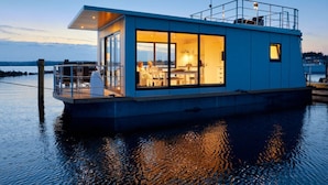 A modern houseboat with a large open kitchen, dining area, and a spacious deck. - Houseboat in Egernsund at the Marina Minde (Broager)