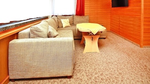 Une pièce chaleureuse avec un canapé, une petite table et un mur en bois.