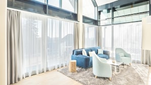Un salon moderne avec un canapé bleu, un fauteuil bleu clair et une table basse.