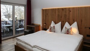 A modern bedroom with a large bed, wooden headboard, and a sliding glass door leading to an outdoor area. - Apartment in Bramberg am Wildkogel With Sauna (Bramberg am Wildkogel)