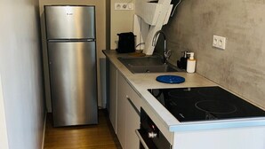 A compact kitchen with a stainless steel refrigerator, a gas stove, and a sink. - 3-star cottage in the countryside with panoramic v (Fiac)