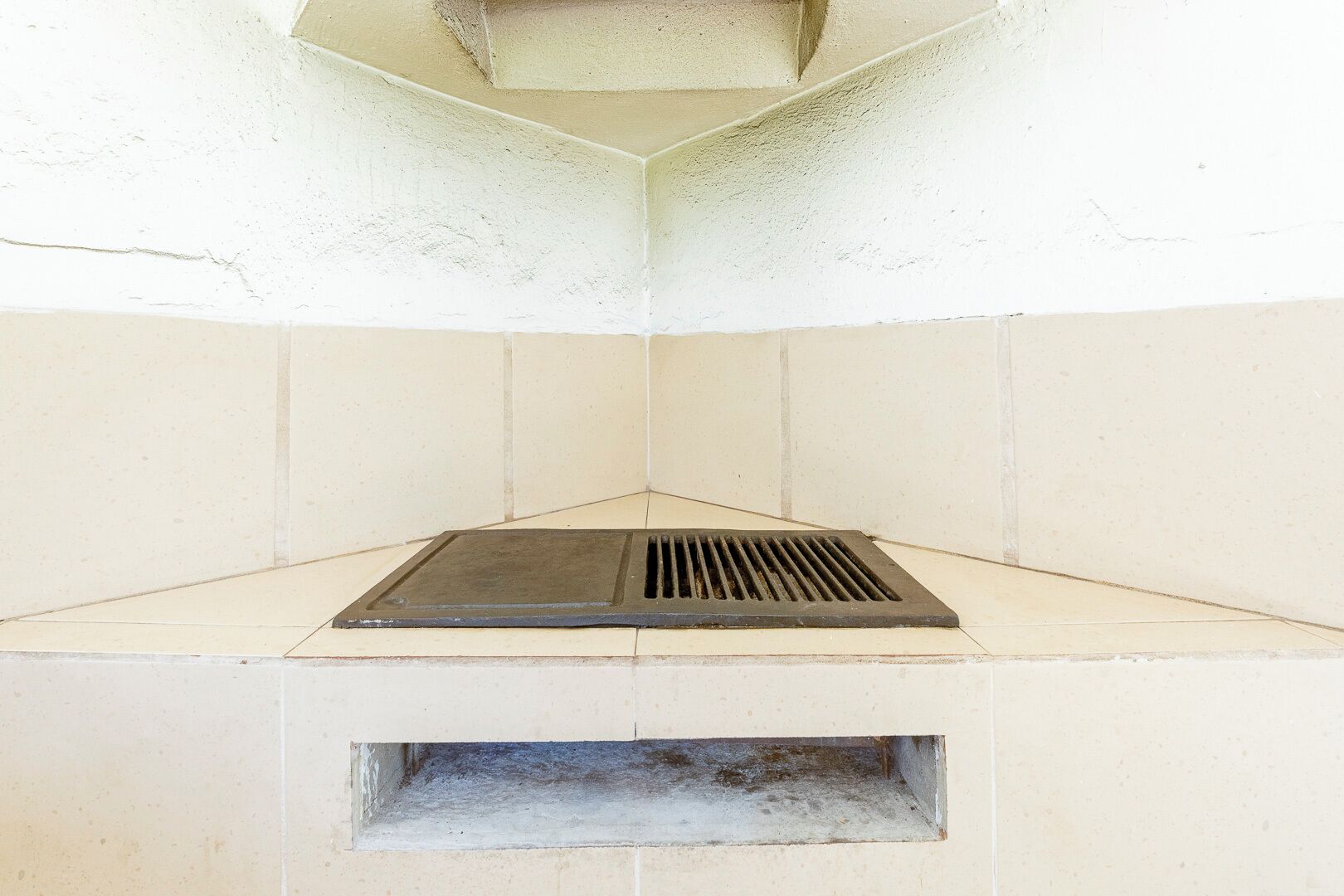 A corner with a built-in grill and a small window below it.
