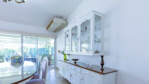 A dining area with a glass table, white cabinets, and a view of the outdoors. - New house with pool and grill area (Cuernavaca)