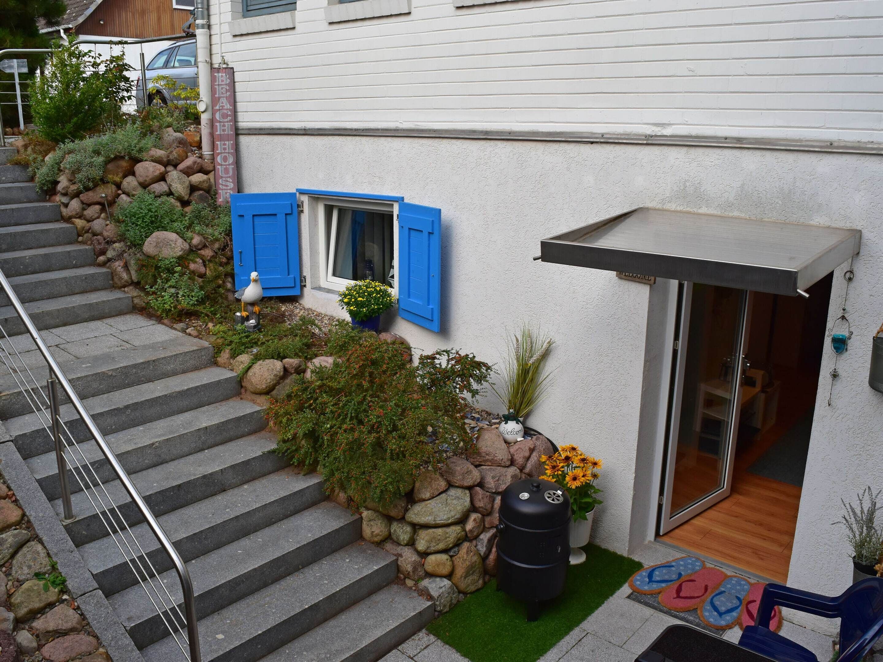 A house with a stone staircase leading to a door with a glass panel.