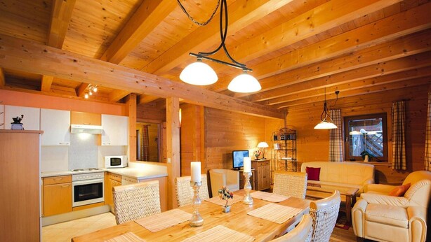 A cozy wooden cabin interior with a dining area, kitchen, and living room. - Chalet in Kitzbuhel Alps Near Hiking Trails (Wildschönau)