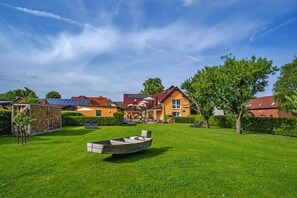 A residential area with houses, a boat, and a well-maintained lawn. - Apartment on the Spree River in Schlepzig (Schlepzig)