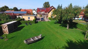 A residential area with houses, a lawn, and a small boat. - Apartment on the Spree River in Schlepzig (Schlepzig)